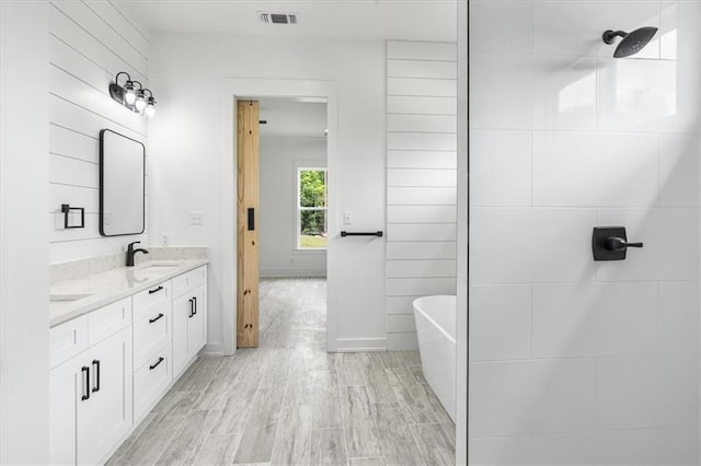 bathroom with double vanity and a washtub