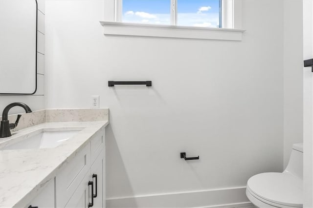 bathroom with plenty of natural light, vanity, and toilet