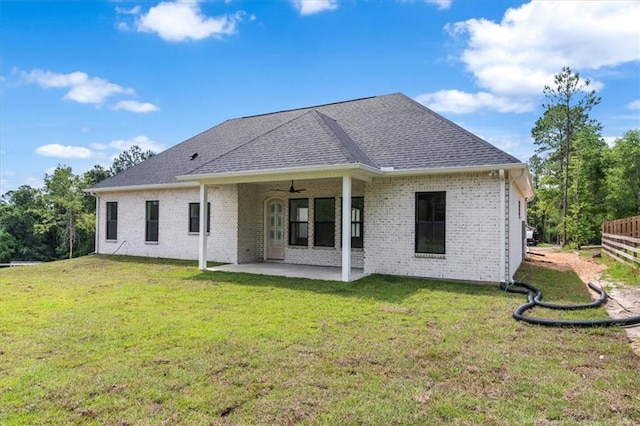 back of property featuring ceiling fan, a lawn, and a patio area