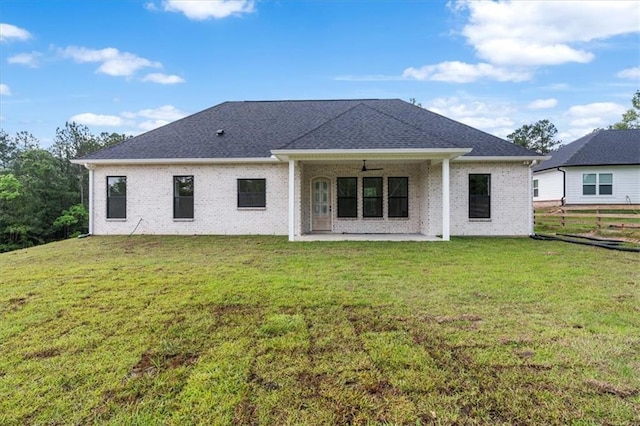 rear view of house with ceiling fan, a lawn, and a patio