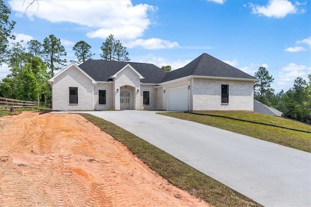 french provincial home featuring a garage and a front lawn