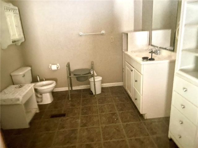 bathroom featuring tile patterned flooring, toilet, a bidet, and vanity