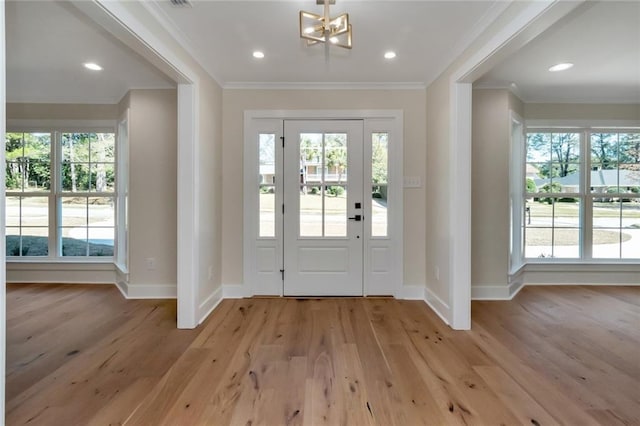 entrance foyer with light wood-style floors, recessed lighting, crown molding, and baseboards