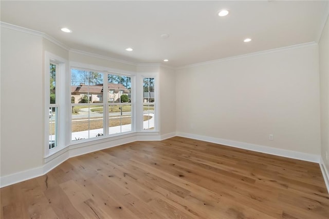 empty room featuring ornamental molding, light wood-type flooring, recessed lighting, and baseboards