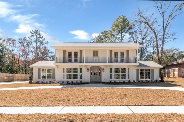 view of front of home featuring a balcony, fence, and french doors