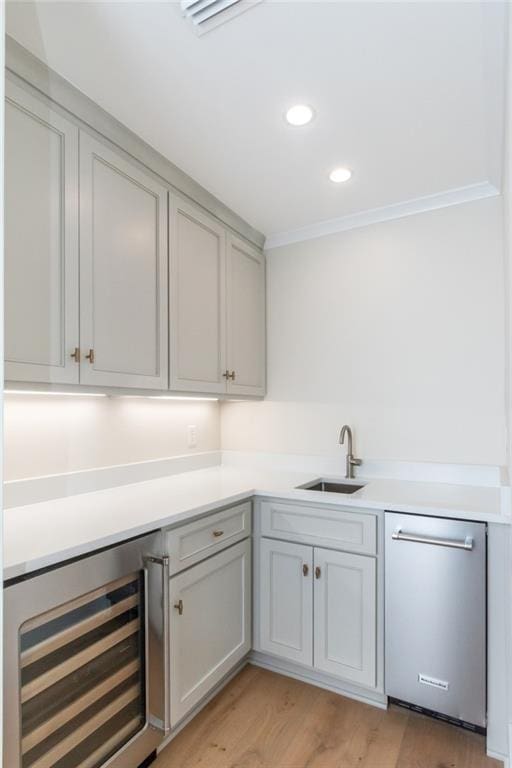 bar with wine cooler, a sink, light wood-style floors, dishwasher, and crown molding