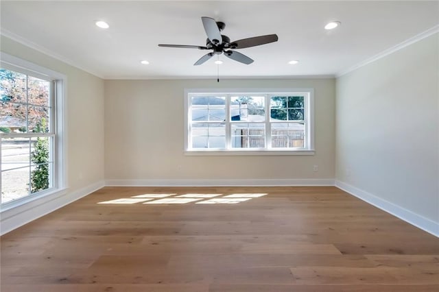 spare room with a healthy amount of sunlight, light wood-style flooring, and ornamental molding