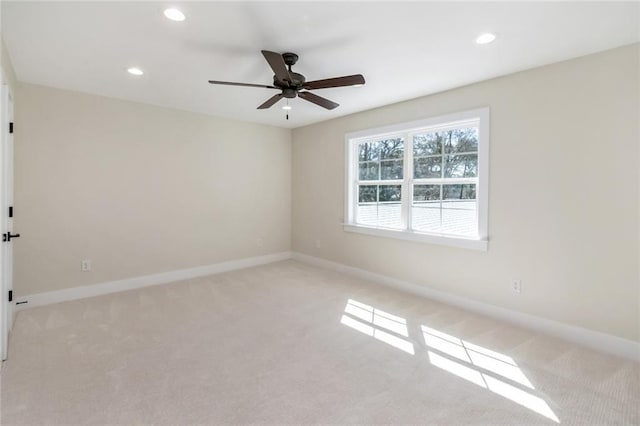 empty room featuring light carpet, baseboards, a ceiling fan, and recessed lighting