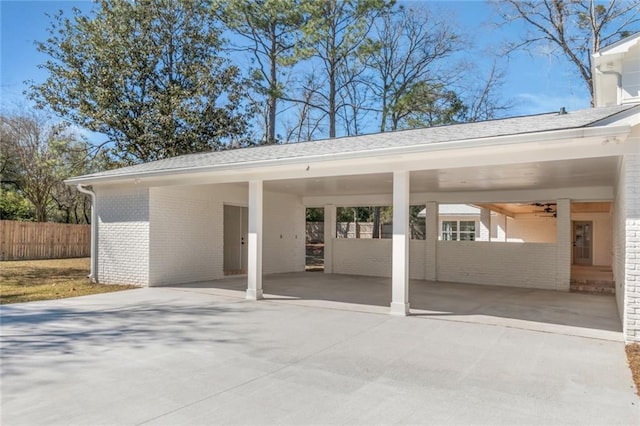 view of patio / terrace featuring a carport, driveway, and fence