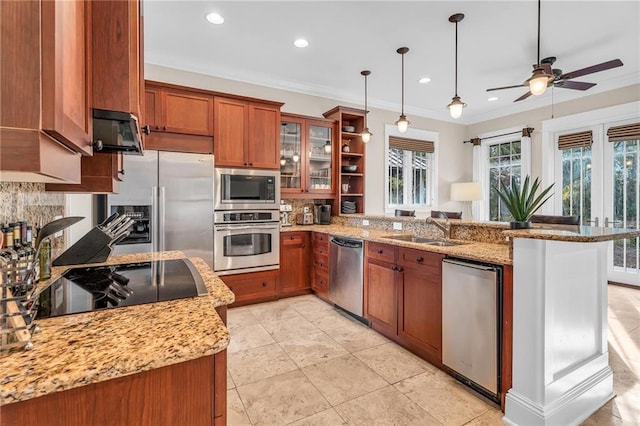 kitchen featuring brown cabinetry, a peninsula, a sink, stainless steel appliances, and backsplash