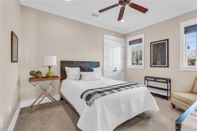 carpeted bedroom with visible vents, crown molding, baseboards, and multiple windows