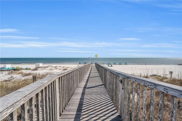 view of community featuring a water view and a beach view