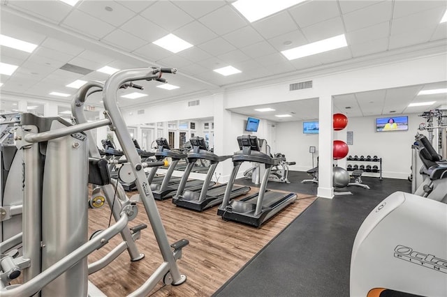 workout area featuring ornamental molding, a paneled ceiling, visible vents, and baseboards