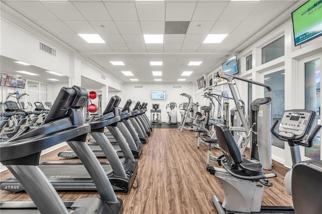 workout area featuring a paneled ceiling, wood finished floors, and visible vents