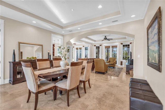 dining space featuring visible vents, arched walkways, ornamental molding, a tray ceiling, and recessed lighting