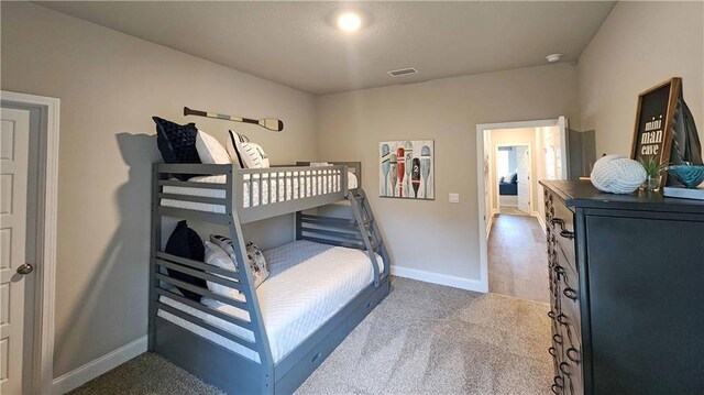 carpeted bedroom featuring baseboards and visible vents