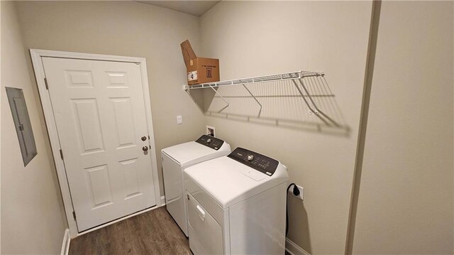 clothes washing area with dark wood-style flooring, laundry area, separate washer and dryer, baseboards, and electric panel
