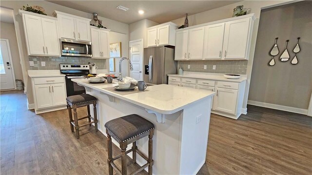 kitchen featuring dark wood-style flooring, stainless steel appliances, and white cabinets