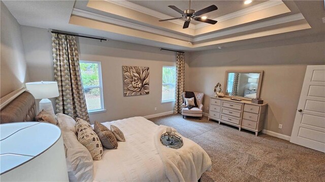 bedroom featuring baseboards, ornamental molding, a tray ceiling, and carpet flooring