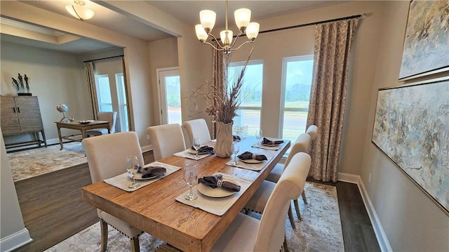 dining area with baseboards, a notable chandelier, and wood finished floors