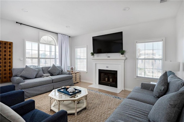 living room with baseboards, light wood finished floors, a fireplace, and recessed lighting