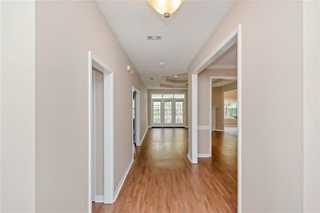 hall with french doors and light hardwood / wood-style flooring