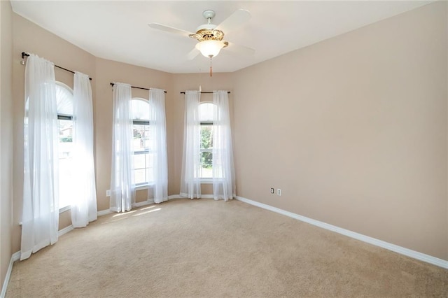 spare room with ceiling fan and light carpet