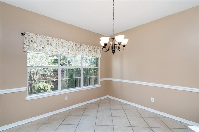 spare room featuring a notable chandelier and light tile patterned flooring