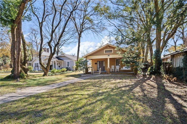 bungalow featuring a porch and a front lawn