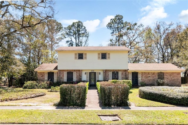 colonial house with brick siding and a front yard