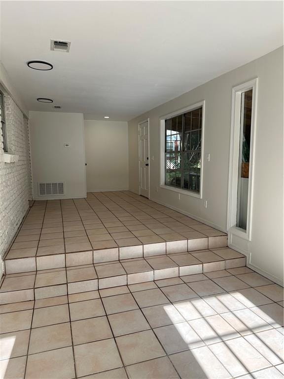 315 Thunderbird Dr, Satsuma, AL 36572 - empty room featuring light tile patterned flooring and brick wall