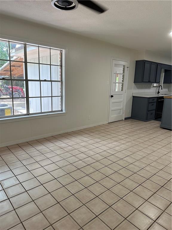 315 Thunderbird Dr, Satsuma, AL 36572 - kitchen with light countertops, a textured ceiling, baseboards, a sink, and backsplash