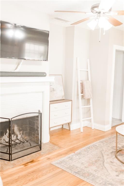 1660 Old Shell Rd, Mobile, AL 36604 - living area with wood finished floors, a ceiling fan, and a fireplace