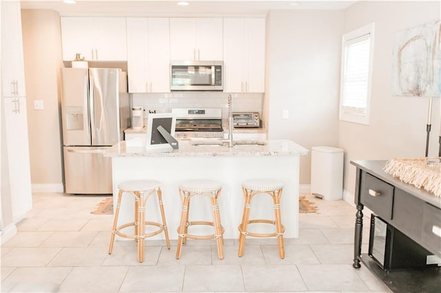 1660 Old Shell Rd, Mobile, AL 36604 - kitchen with stainless steel microwave, refrigerator with ice dispenser, white electric range, tasteful backsplash, and white cabinets