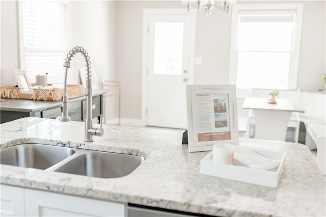 1660 Old Shell Rd, Mobile, AL 36604 - kitchen with light stone counters, white cabinetry, and a chandelier