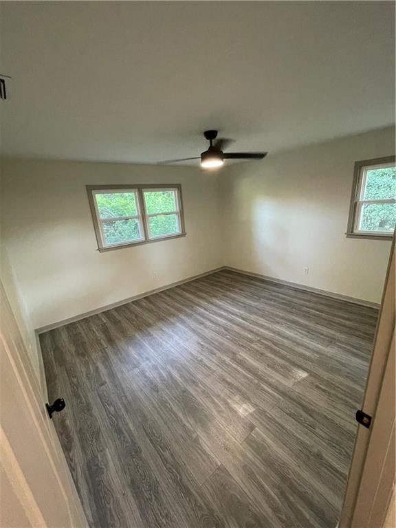 empty room featuring ceiling fan and dark hardwood / wood-style floors