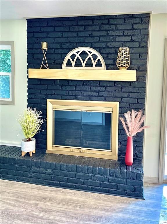 room details with wood-type flooring and a brick fireplace