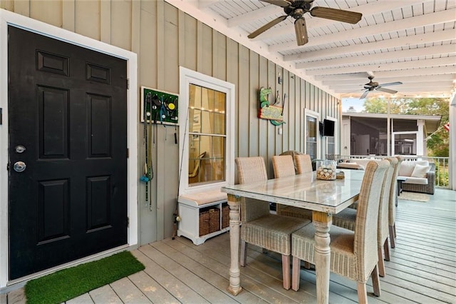 exterior space with a sunroom, outdoor dining space, and a ceiling fan