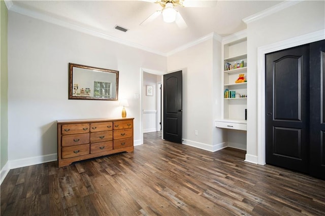 bedroom featuring baseboards, dark wood-type flooring, built in study area, and crown molding