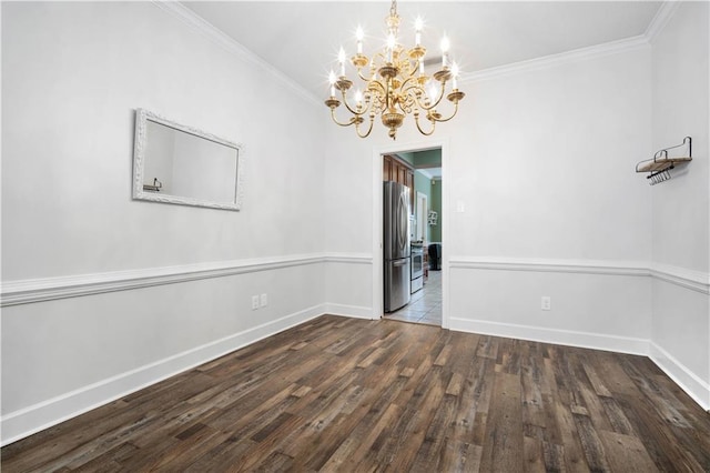 empty room featuring baseboards, ornamental molding, a chandelier, and wood finished floors