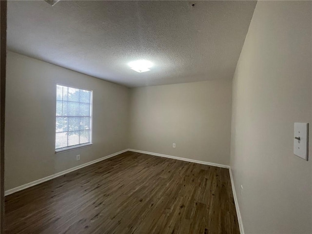 unfurnished room featuring baseboards, a textured ceiling, and dark wood-style flooring