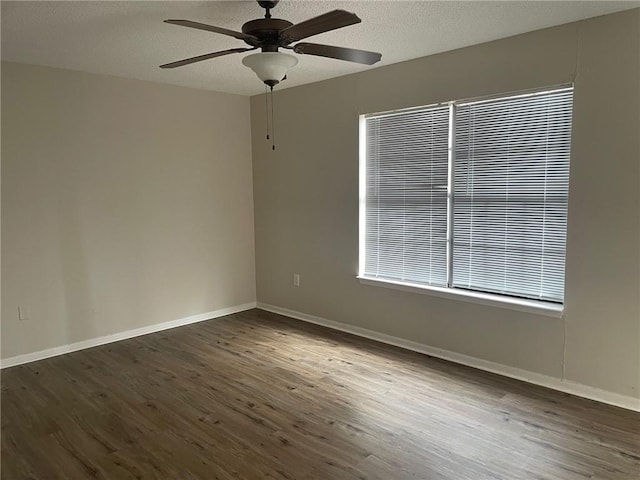 empty room featuring ceiling fan, a textured ceiling, baseboards, and wood finished floors