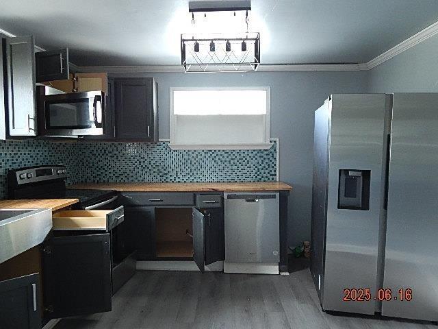 1021 Cherry St, Mobile, AL 36610 - kitchen featuring stainless steel appliances, crown molding, wood finished floors, decorative backsplash, and wood counters