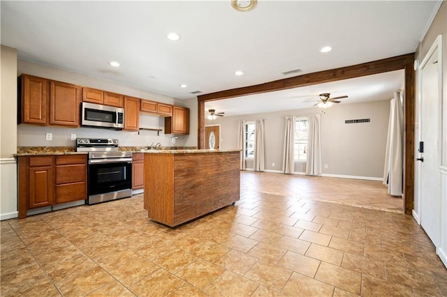 kitchen featuring beam ceiling, ceiling fan, light stone counters, light tile patterned flooring, and appliances with stainless steel finishes