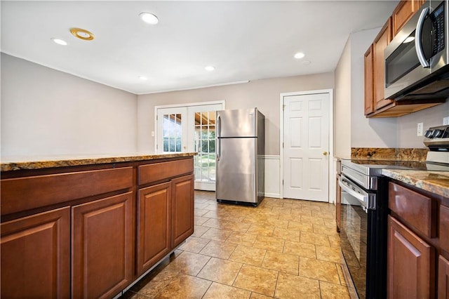 kitchen featuring appliances with stainless steel finishes, light stone counters, and french doors