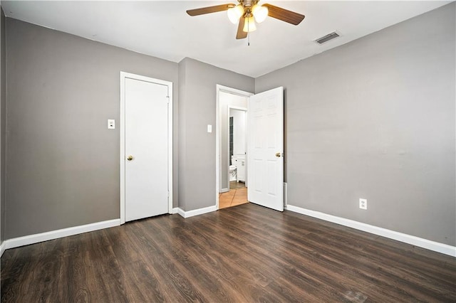 unfurnished bedroom featuring ceiling fan and dark hardwood / wood-style flooring