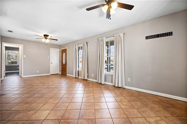 tiled spare room with ceiling fan