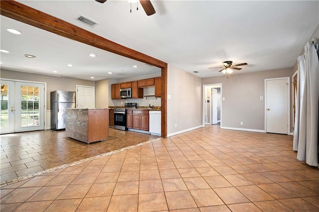 kitchen with french doors, ceiling fan, light tile patterned floors, appliances with stainless steel finishes, and a kitchen island