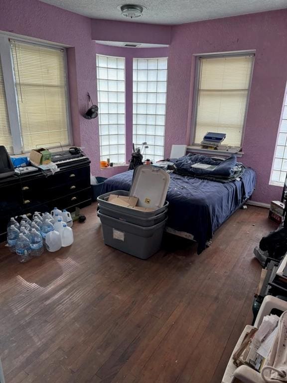 bedroom featuring hardwood / wood-style flooring and a textured ceiling