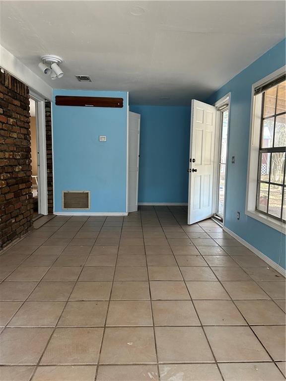 unfurnished room with light tile patterned flooring, baseboards, and visible vents